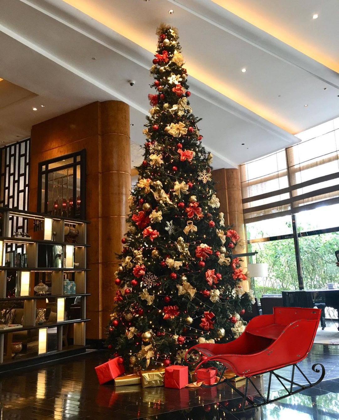 Weihnachtsdekoration in Hotel: großer Weihnachtsbaum und Weihnachtsschlitten